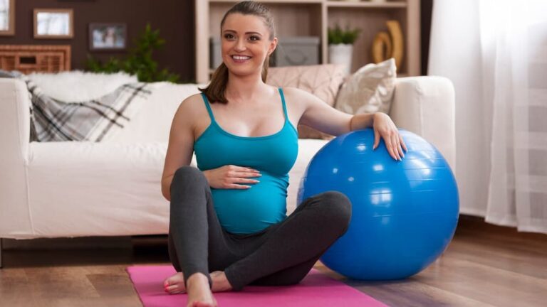 Mulher grávida se exercitando em casa